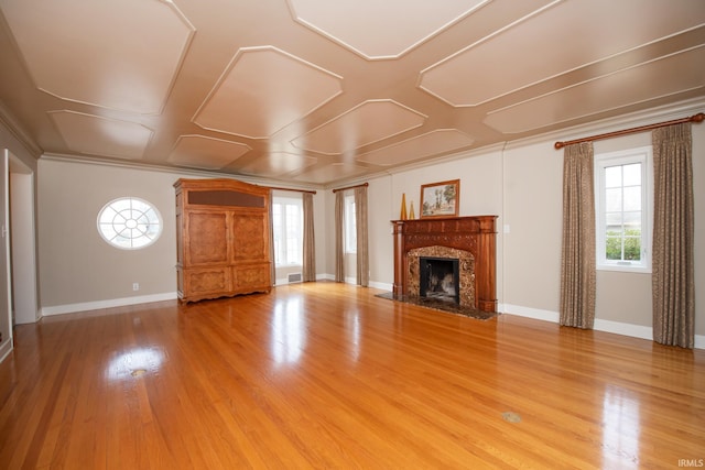 unfurnished living room with light wood-style flooring, baseboards, ornamental molding, and a high end fireplace