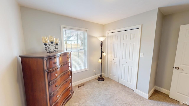 interior space with visible vents, light carpet, baseboards, and multiple windows