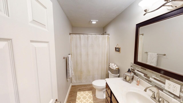 bathroom featuring curtained shower, toilet, wood finished floors, vanity, and baseboards