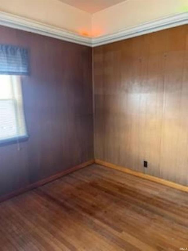 unfurnished room featuring baseboards and wood finished floors