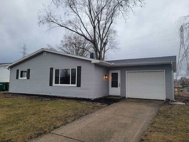 single story home featuring driveway, a front yard, and an attached garage