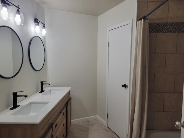 bathroom with a sink, baseboards, shower / tub combo with curtain, and double vanity