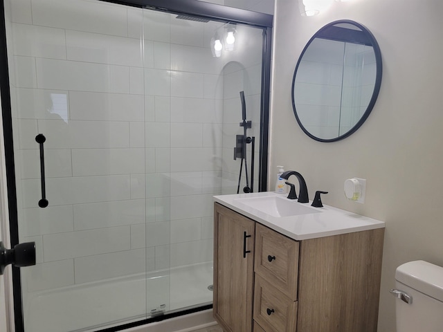 bathroom featuring vanity, toilet, and a shower stall