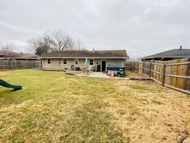 rear view of property with a patio area, a yard, a fenced backyard, and a playground