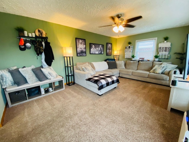 living area with a textured ceiling, carpet, and a ceiling fan