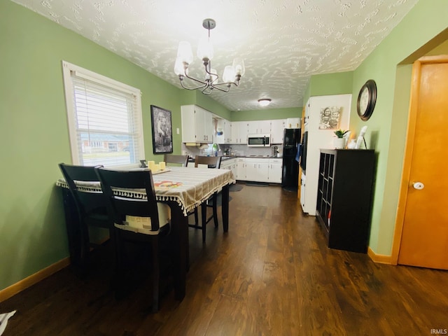 dining space featuring an inviting chandelier, baseboards, dark wood-type flooring, and a textured ceiling