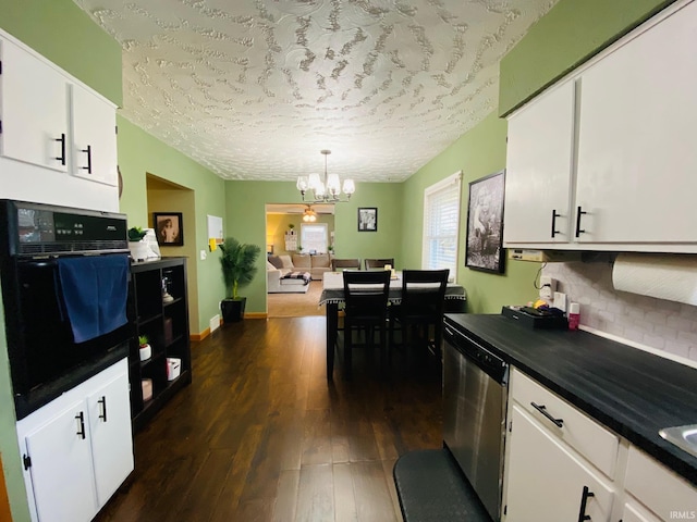 kitchen with dark wood finished floors, dishwasher, an inviting chandelier, white cabinetry, and black oven