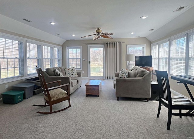 carpeted living room featuring lofted ceiling, a healthy amount of sunlight, and visible vents