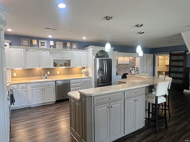 kitchen featuring dark wood-style floors, recessed lighting, appliances with stainless steel finishes, white cabinetry, and a sink