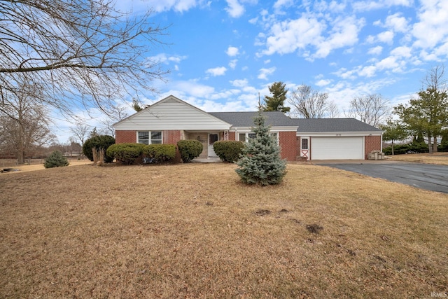 single story home featuring driveway, a garage, a front lawn, and brick siding