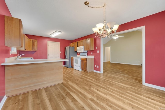 kitchen featuring light wood-style floors, white appliances, light countertops, and a sink