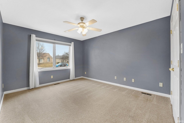 carpeted spare room with ceiling fan, visible vents, and baseboards