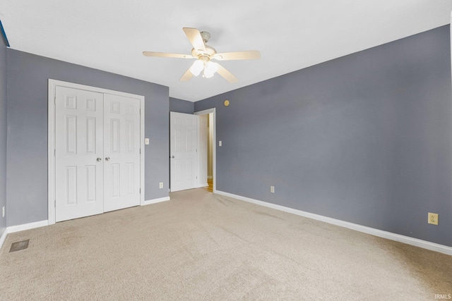 unfurnished bedroom with visible vents, a closet, baseboards, and carpet flooring