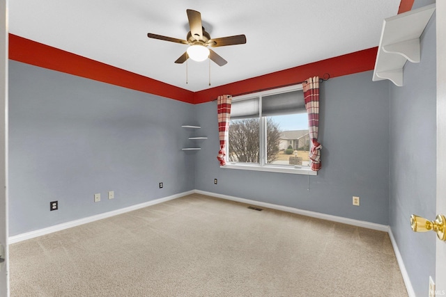 spare room featuring ceiling fan, carpet flooring, visible vents, and baseboards