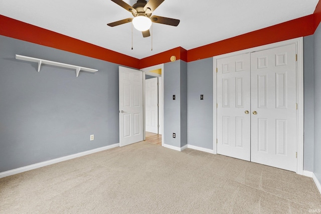 unfurnished bedroom with carpet floors, a ceiling fan, baseboards, and a closet