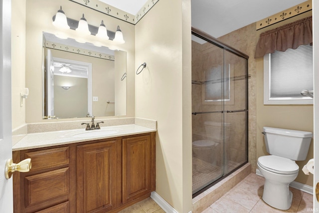 bathroom featuring toilet, a shower stall, vanity, and tile patterned floors