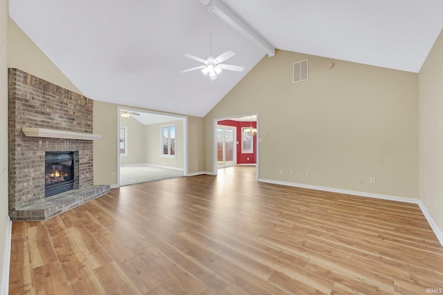 unfurnished living room featuring beam ceiling, a fireplace, visible vents, a ceiling fan, and light wood-style floors