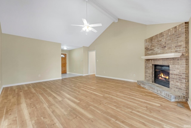 unfurnished living room with light wood-type flooring, beamed ceiling, a brick fireplace, and baseboards