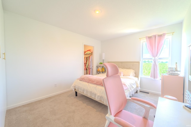 bedroom featuring a closet, carpet flooring, a spacious closet, and baseboards