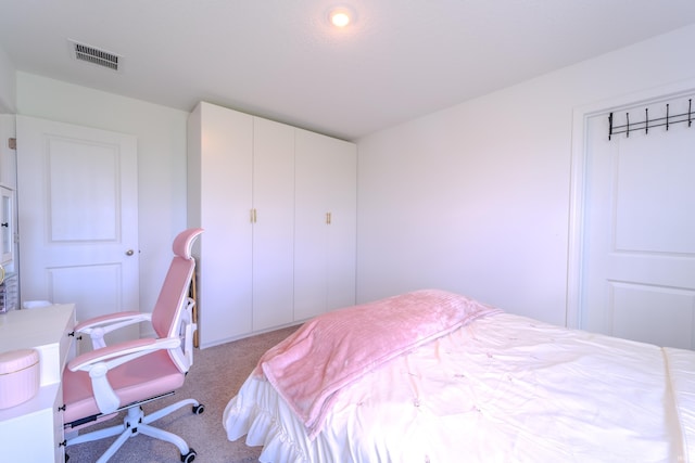 carpeted bedroom with a closet and visible vents