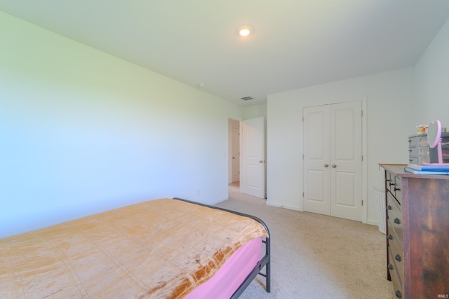 bedroom featuring baseboards, a closet, visible vents, and light colored carpet