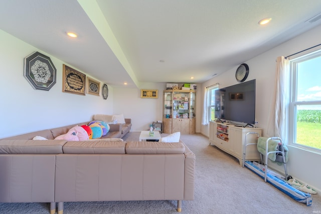 living area with light carpet, visible vents, and recessed lighting