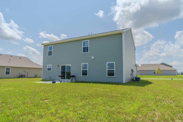 back of house with central air condition unit, a lawn, and a patio