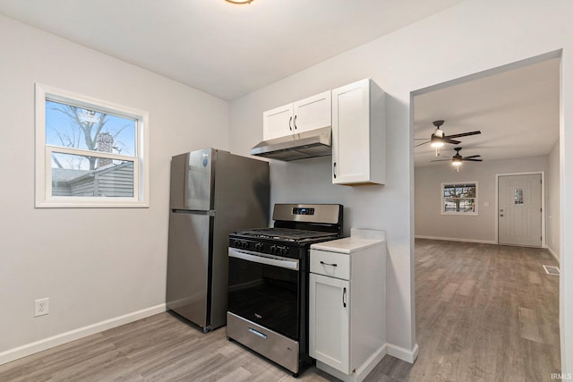 kitchen featuring light countertops, light wood-style flooring, appliances with stainless steel finishes, white cabinetry, and under cabinet range hood