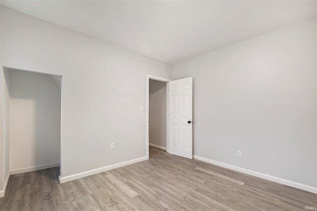 empty room with baseboards and wood finished floors