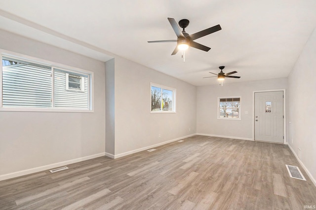 unfurnished room featuring baseboards, visible vents, and light wood-style floors