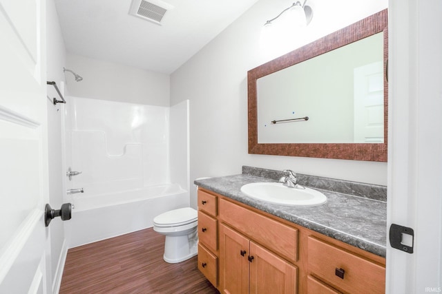 bathroom with bathtub / shower combination, visible vents, toilet, vanity, and wood finished floors