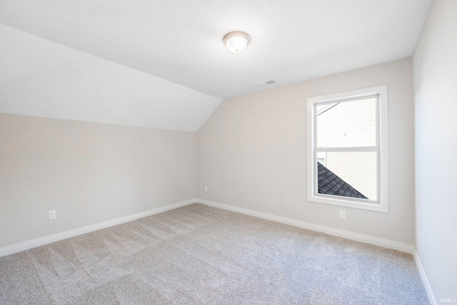 bonus room with lofted ceiling, visible vents, light carpet, and baseboards