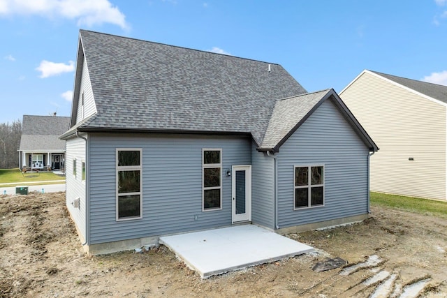 back of house with a shingled roof and a patio area