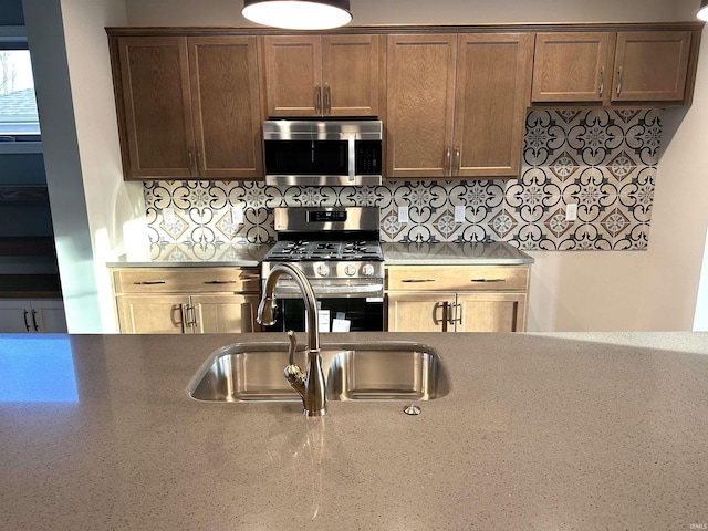 kitchen with stainless steel appliances, a sink, and backsplash