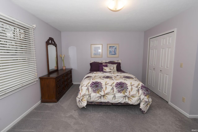 bedroom with carpet floors, baseboards, and a closet