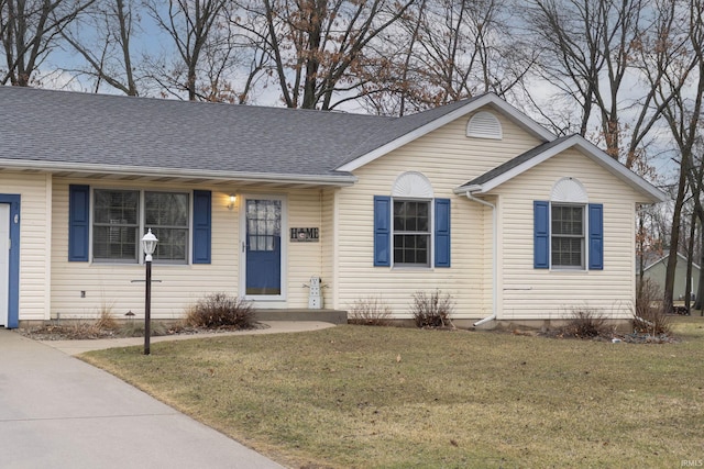 ranch-style house with a shingled roof and a front lawn