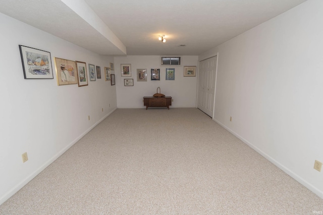 unfurnished room with light carpet and baseboards