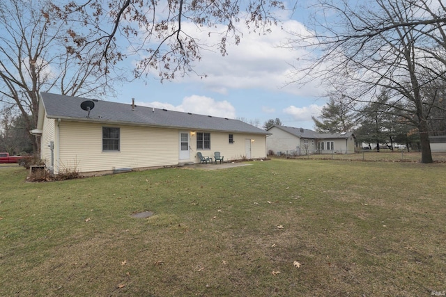 rear view of house featuring a lawn and a patio