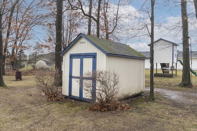 view of shed with driveway and fence