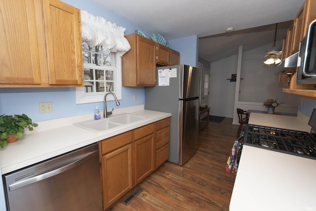 kitchen featuring dark wood-style floors, stainless steel appliances, light countertops, a ceiling fan, and a sink