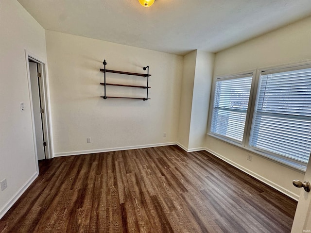 empty room featuring baseboards and wood finished floors