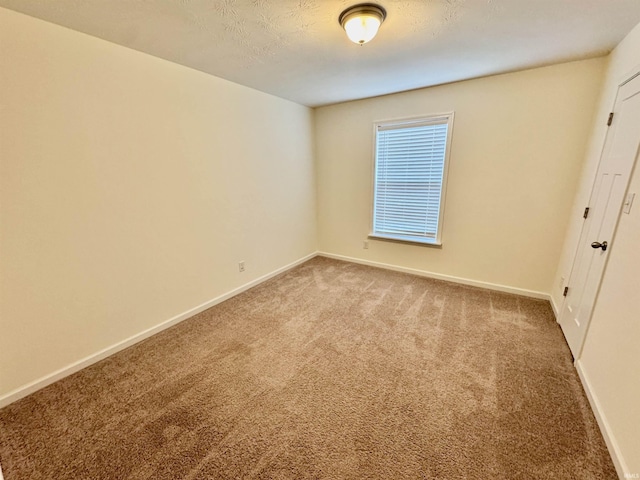 unfurnished bedroom featuring a textured ceiling, baseboards, and carpet flooring