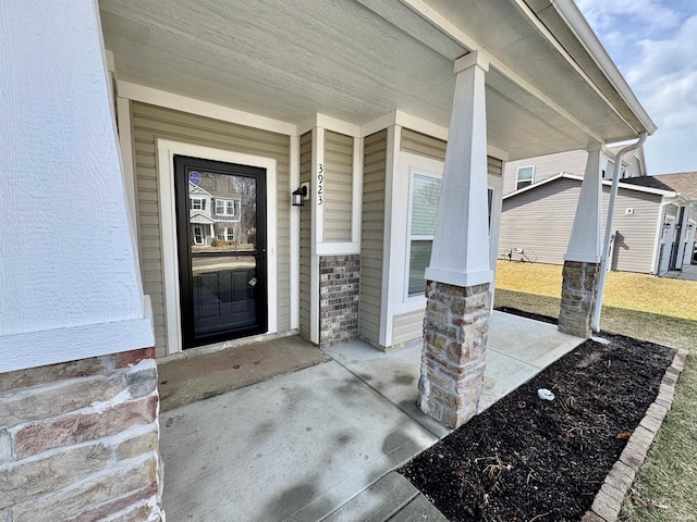 entrance to property featuring a porch and stucco siding