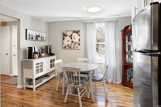 dining room featuring light wood-style flooring and baseboards