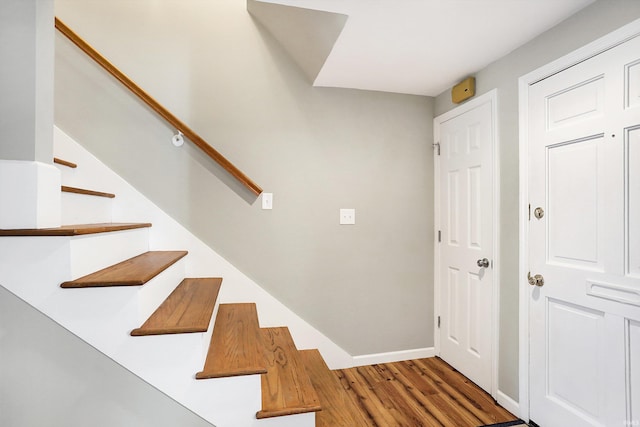 staircase with wood finished floors and baseboards