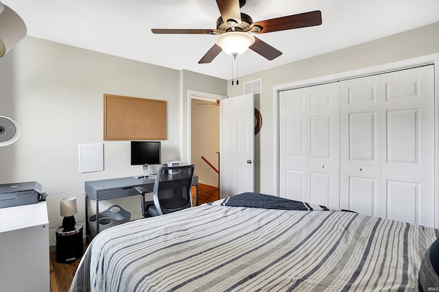 bedroom featuring dark wood-style flooring, a closet, visible vents, and a ceiling fan