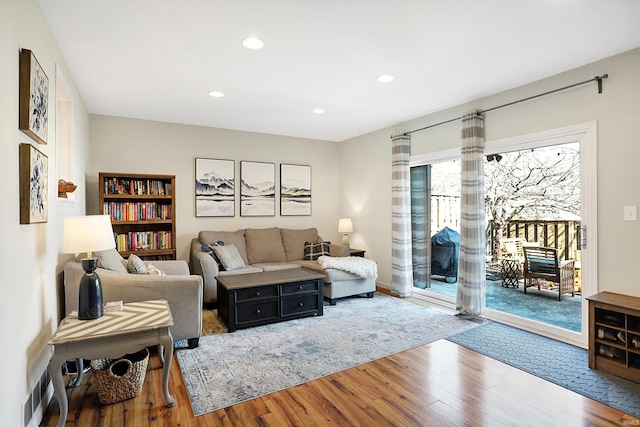 living area with visible vents, wood finished floors, and recessed lighting