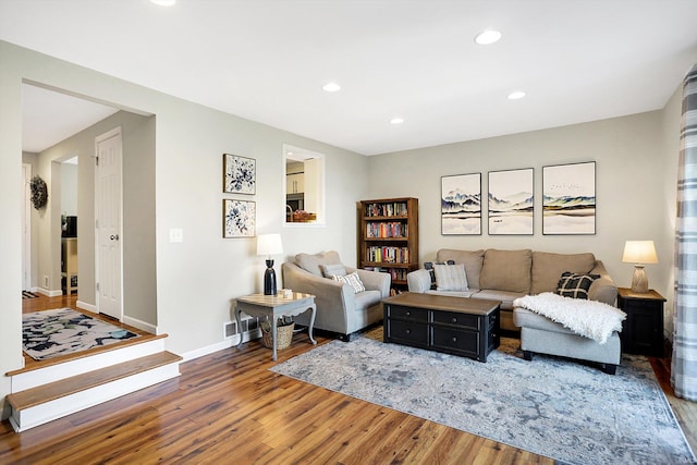 living area with recessed lighting, visible vents, baseboards, and wood finished floors