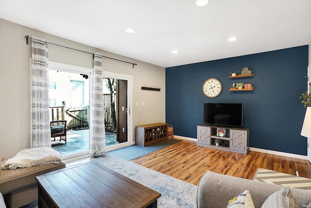 living room featuring recessed lighting, wood finished floors, and baseboards