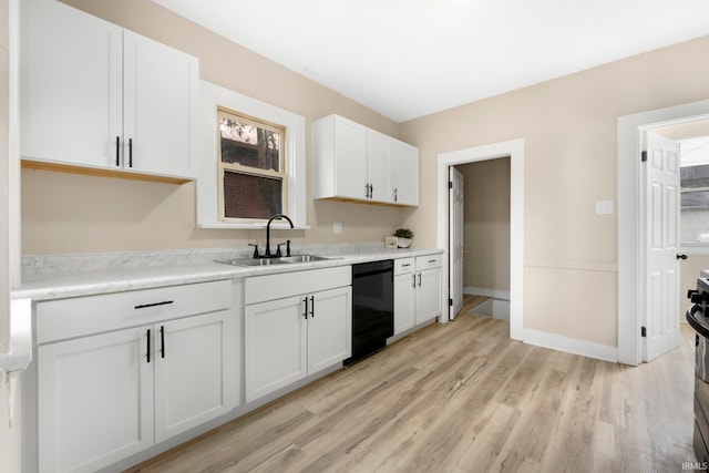 kitchen featuring light wood-style flooring, light countertops, black appliances, white cabinetry, and a sink